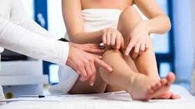 The doctor examines the patient's foot